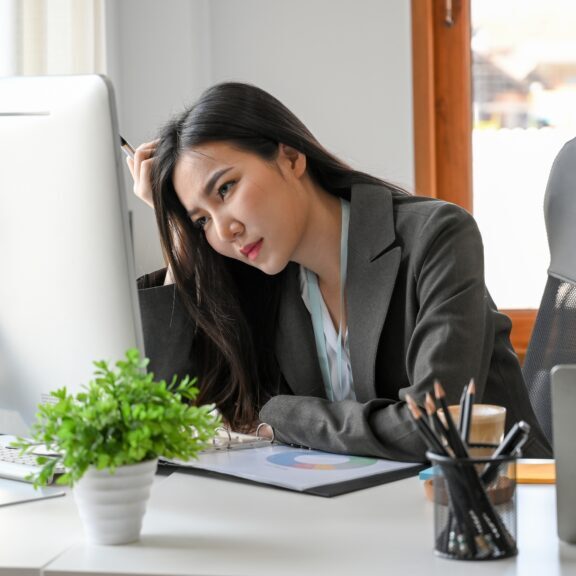 A,Tired,Businesswoman,Sits,At,Her,Desk,In,The,Office,